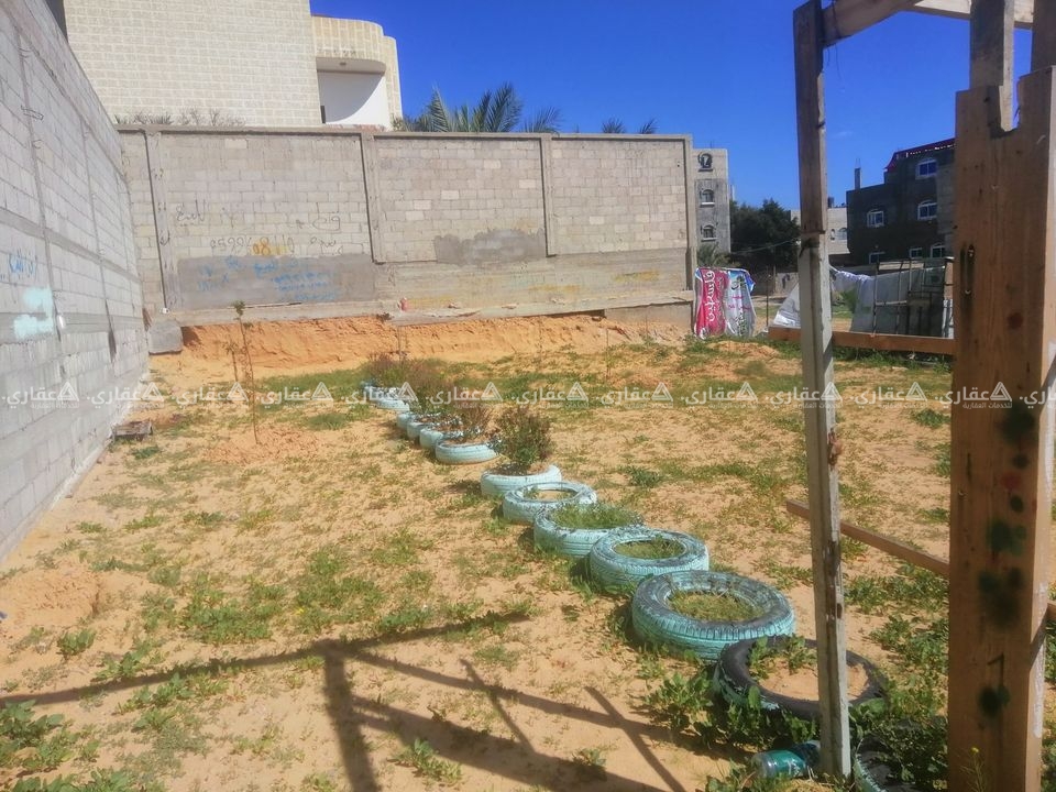 قطعة أرض مسيجة ومحاذة بسورين من حجارة