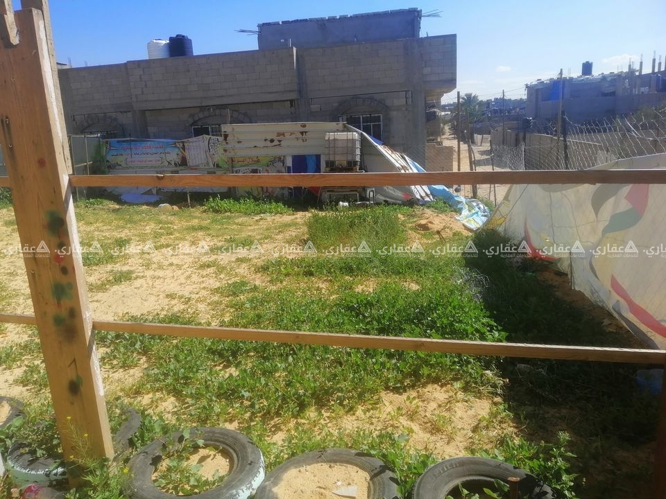 قطعة أرض مسيجة ومحاذة بسورين من حجارة